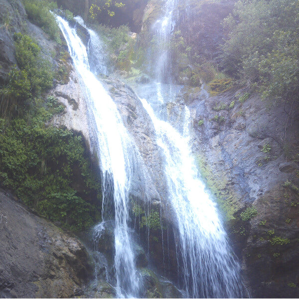 Tall waterfall spilling down a mossy cliff